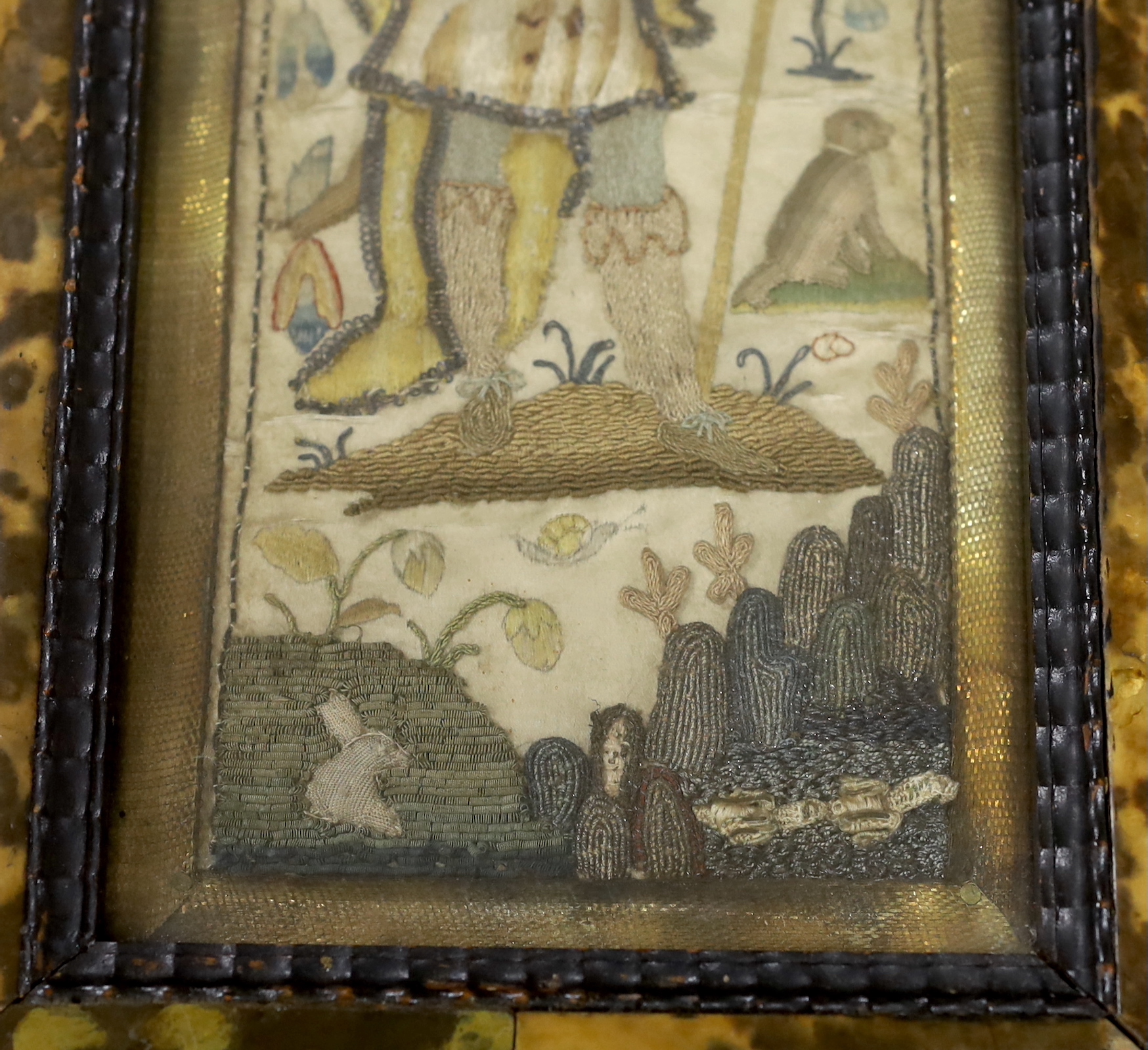 A framed 17th century stumpwork embroidery panel, embroidered with a central figure of a nobleman or king, possibly Henry VIII, holding a staff, wearing a cloth of gold with his dog in the grounds of a castle (possibly N